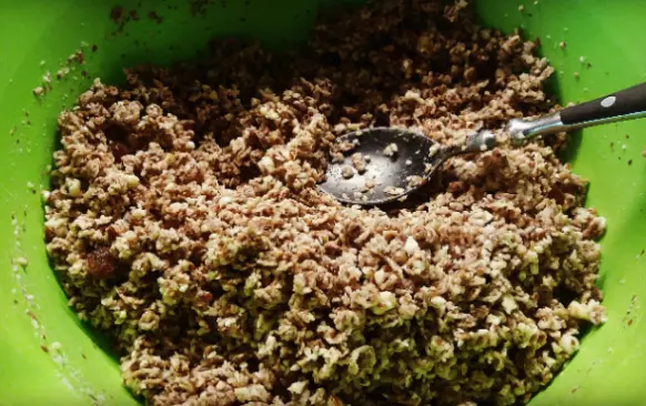 Do misky si nasypeme pohankové vločky a rozmixované ořechy. Přidáme mléko a mícháme tak, aby se mléko s vločkami a ořechy spojilo. Potom těsto do slova vmačkáme lžící do dortové formy. Pečeme na 200 stupňů 20 minut.