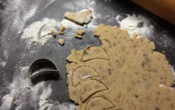 Do prosáté mouky přidáme citrónovou kůru,cukr,mandlovou mouku,rozsekané hrozinky,tlučený hřebíček a skořici. Těsto spojíme žloutky a máslem a vypracujeme.Necháme v lednici odležet (třeba přes noc). Vyválíme 3 mm silný plát a vykrojíme půlměsíčky.
Pečeme dorůžova. Pak je ještě teplé na plechu potřeme citrónovou polevou,kterou si umícháme z prosátého moučkového cukru a citrónové šťávy. 

Poznámky:
V původním receptu bylo 140 g cukru,já použila 100g. Na spojení surovin,byly uvedeny jen 2 vejce,směs byla sypká,tak jsem přidala 125 g másla. V původním receptu,se udělalo těsto a hned se vyválelo...já dala na noc odležet,ať se chutě a vůně krásně propojí.