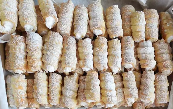 Po upečení je ihned sundáme z trubiček a necháme vychladnout na rovné podložce.
Jahody nakrájíme na malé kousky, přilijeme k nim obě šlehačky a přidáme ztužovače. Vše našleháme dotuha. Přisladíme podle chuti a šlehačkou naplníme trubičky. Trubičky pak pocukrujeme moučkovým cukrem .