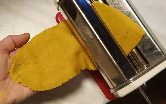 Těsto krátce prohněteme a vyválíme. Utvoříme čtverečky nebo obdélníčky. Na tvaru až tak nezáleží. Krásně se to válí bez lepení na silikonové podložce a přes fólii. 
Pokud máte strojek na těstoviny, protáhneme strojkem na č. 5. Nižší stupeň nedoporučuji, pak je těsto příliš tenké a může se trhat.
Jak vidno, kousky těstovin nejsou přesné čtverečky či obdélníky, vůbec to nevadí.