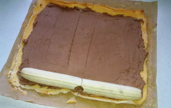 Krém: Smetanu šlehejte se ztužovačem téměř do zhoustnutí. Chvíli před došleháním přisypte kakao a došlehejte dotuha. Vznikne jednoduchá pařížská šlehačka. 3/4 krému potřete vychladlý plát a na kraj položte rozřízlý oloupaný banán. Roládu smotejte a nechejte v chladnu odpočinout.