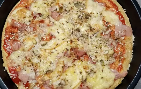 Vejce smíchat s moukami, 
olejem, prdopečem a pizza kořením dle uvážení a chuti,přidat asi decku vody, vyšlehat ručním šlehačem, kdyby bylo těsto stále tuhé přidat ještě vodu asi tolik aby těsto bylo řidší. Nalít do olejem vymazané zapékací formy potřít rajčatovým pyrém a péct v předehřáté troubě na 200 stupňů asi 10 min. Pak vyndat posypat šunkou nakrájenou na proužky, sýrem, já ještě posypala semínky slunečnicí, dýňová a seznam  nebo tím co kdo má rád, posypat ještě pizza kořením nebo jen oreganem a zase zapéct do zlatova.