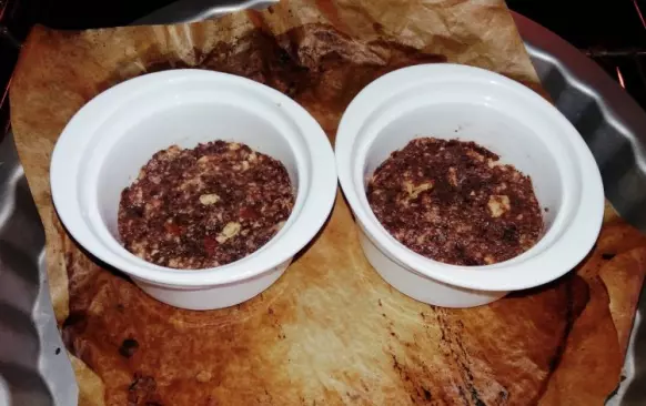 Oboje sušenky rozmačkejte na malé kousky, přidejte nahrubo posekané pekany a zalejte troškou mléka (může být i rostlinné). Tuto hmotu natlačte do zapékacích mističek a dejte do předehřáté trouby na 180 stupňů asi na 10 minut.